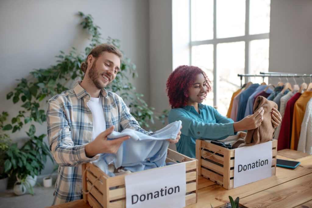 Volunteers sorting clothes into donation boxes