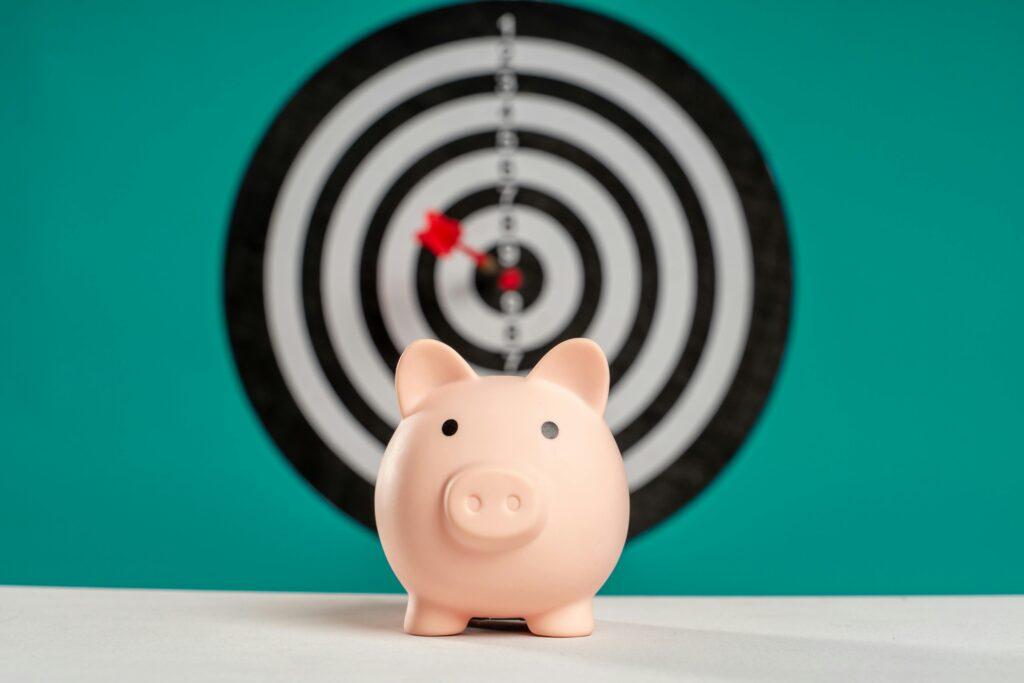 piggy bank in front of a dartboard, symbolising financial targeting