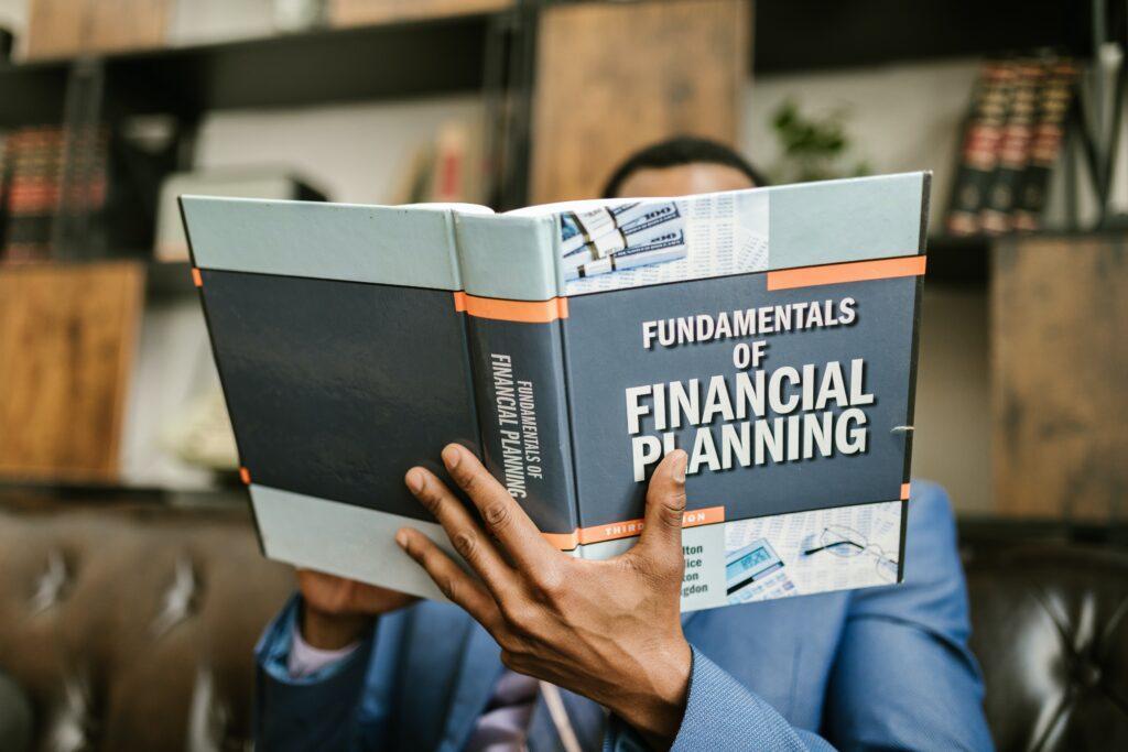man reading fundamentals of financial planning book
